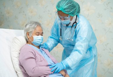 Yüz maskesi takan Asyalı bir doktor ve karantina hastanesi koğuşundaki Covid-19 Coronavirus salgınını kontrol etmek için PPE giysisi..