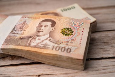Tahta arka planda Tayland baht banknotları yığını, iş tasarrufu finans yatırım kavramı.