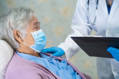 Yüz maskesi takan Asyalı bir doktor ve karantina hastanesi koğuşundaki Covid-19 Coronavirus salgınını kontrol etmek için PPE giysisi..