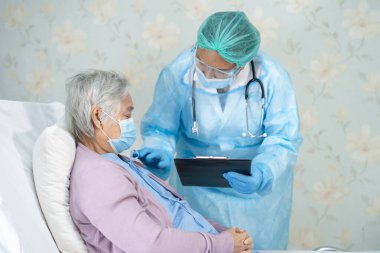 Yüz maskesi takan Asyalı bir doktor ve karantina hastanesi koğuşundaki Covid-19 Coronavirus salgınını kontrol etmek için PPE giysisi..