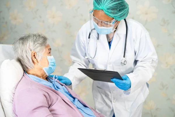 Yüz maskesi takan Asyalı bir doktor ve karantina hastanesi koğuşundaki Covid-19 Coronavirus salgınını kontrol etmek için PPE giysisi..