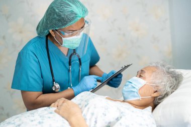 Yüz maskesi takan Asyalı bir doktor ve karantina hastanesi koğuşundaki Covid-19 Coronavirus salgınını kontrol etmek için PPE giysisi..