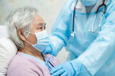 Yüz maskesi takan Asyalı bir doktor ve karantina hastanesi koğuşundaki Covid-19 Coronavirus salgınını kontrol etmek için PPE giysisi..