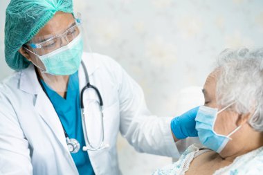 Yüz maskesi takan Asyalı bir doktor ve karantina hastanesi koğuşundaki Covid-19 Coronavirus salgınını kontrol etmek için PPE giysisi..