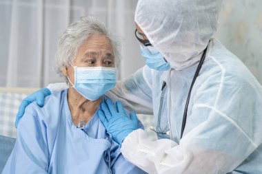 Yüz maskesi takan Asyalı bir doktor ve karantina hastanesi koğuşundaki Covid-19 Coronavirus salgınını kontrol etmek için PPE giysisi..