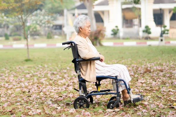 亚洲老年老年妇女病人在公园坐轮椅时膝部疼痛 健康有力的医疗理念 — 图库照片