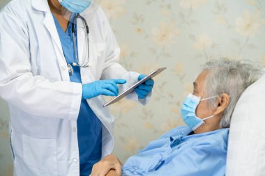 Yüz maskesi takan Asyalı bir doktor ve karantina hastanesi koğuşundaki Covid-19 Coronavirus salgınını kontrol etmek için PPE giysisi..