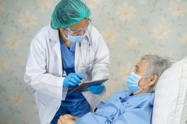 Yüz maskesi takan Asyalı bir doktor ve karantina hastanesi koğuşundaki Covid-19 Coronavirus salgınını kontrol etmek için PPE giysisi..