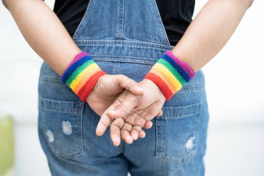 Gökkuşağı bilekliği takan Asyalı kadın, LGBT onur ayının sembolü Haziran sosyal ortamında gey, lezbiyen, biseksüel, transseksüel, insan hakları.