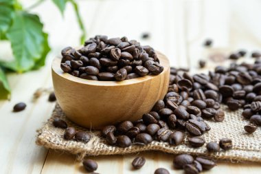 Kahve çekirdeği, taze bir sabah yaprağıyla ahşap kasede kavrulmuş..