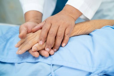 Doktor el ele tutuşuyor Asyalı yaşlı ya da yaşlı kadın hasta sevgi, ilgi, yardım, cesaret ve empati ile hemşire hastanesi koğuşunda sağlıklı güçlü tıbbi konsept