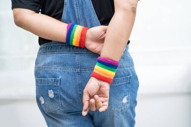 Gökkuşağı bilekliği takan Asyalı kadın, LGBT onur ayının sembolü Haziran sosyal ortamında gey, lezbiyen, biseksüel, transseksüel, insan hakları.