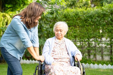 Bakıcı yardım ve bakım Asyalı yaşlı kadın hasta hemşire hastanesi koğuşunda tekerlekli sandalyede oturuyor, sağlıklı ve güçlü..