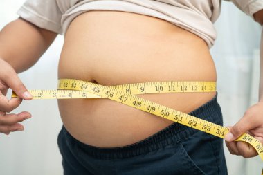 Şişman göbekli, kilolu, kilolu ve mezuralı Asyalı bir kadın..