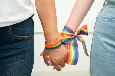 Gökkuşağı bilekliği takan Asyalı LGBT çifti..