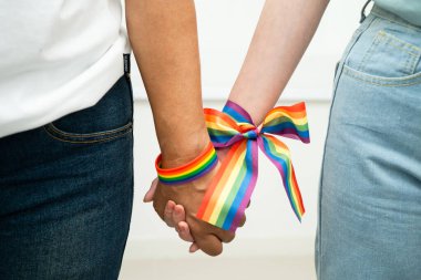 Gökkuşağı bilekliği takan Asyalı LGBT çifti..
