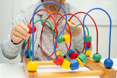 Asyalı yaşlı bir kadın, geliştirme oyunu oynuyor..