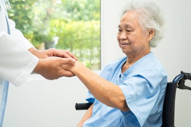 Doktor yardımı ve bakımı, hastanede tekerlekli sandalyedeki Asyalı yaşlı kadın..
