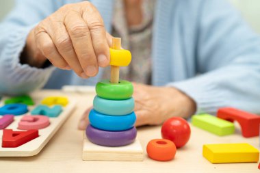 Alzheimer Hastalığı AD, bunama geçiren Asyalı yaşlı kadın hasta pratik motor beceri rehabilitasyonu öğreniyor.