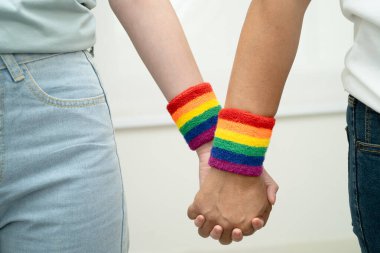 Gökkuşağı bilekliği takan Asyalı LGBT çifti..
