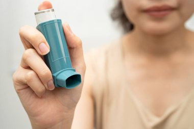 Astım ve kronik obstrüktif akciğer hastalığı COPD, ölçülü doz solunum cihazı kullanan Asyalı kadın..