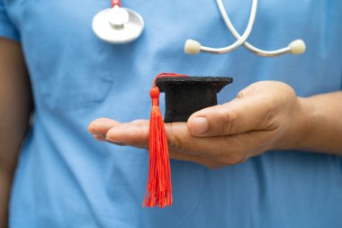 Asyalı doktor eğitimi, hastane koğuşunda mezuniyet şapkasıyla, zeki zeki dahi eğitim tıbbıyla öğreniyor..