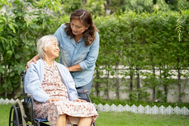 Bakıcı yardım ve bakım Asyalı yaşlı kadın hasta hemşire hastanesi koğuşunda tekerlekli sandalyede oturuyor, sağlıklı ve güçlü..