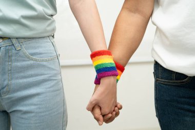 Gökkuşağı bilekliği takan Asyalı LGBT çifti..