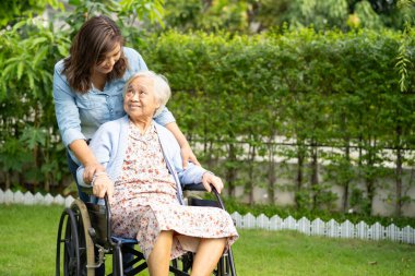 Bakıcı yardım ve bakım Asyalı yaşlı kadın hasta hemşire hastanesi koğuşunda tekerlekli sandalyede oturuyor, sağlıklı ve güçlü..