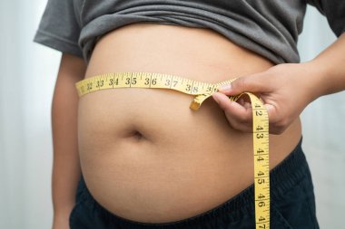 Şişman göbekli, kilolu, kilolu ve mezuralı Asyalı bir kadın..