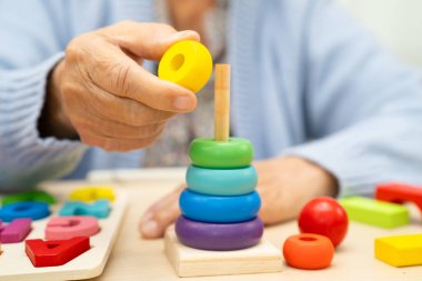 Alzheimer Hastalığı AD, bunama geçiren Asyalı yaşlı kadın hasta pratik motor beceri rehabilitasyonu öğreniyor.