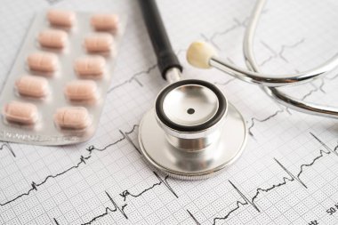 Elektrokardiyogramda stetoskop. Kapsül ilacı, kalp dalgası, kalp krizi, kardiyogram raporu..