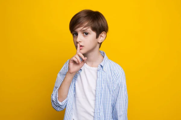 Νεαρός Καυκάσιος ρίχνει τη σιωπή κάνοντας τον σοβαρό σε έναν κίτρινο τοίχο στούντιο με καθημερινά ρούχα. — Φωτογραφία Αρχείου