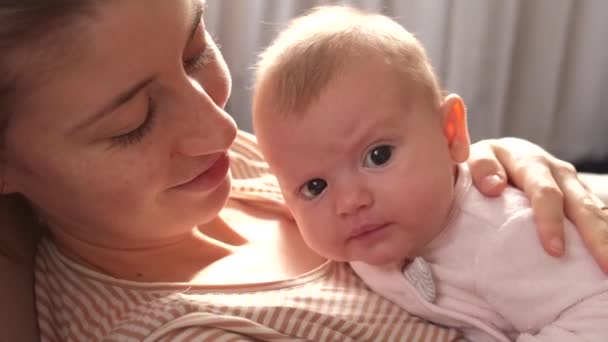 Caucásico bebé recién nacido acostado en su pecho madre y mirando a la cámara haciendo sonreír a sus padres — Vídeos de Stock