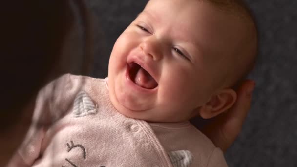 위에서 찍은 사진, 손에 쥐고 있는 어머니를 향해 웃고 있는 주 된 갓난아기의 모습 — 비디오