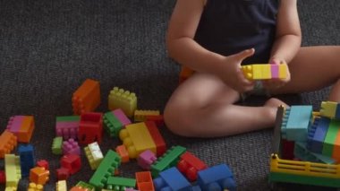 İnşaatçı bloğuyla oynayan küçük bir çocuğun videosunu kapat.