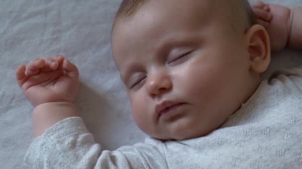 Biri onu filme alırken beyaz bir battaniyenin üzerinde uyuyan yeni doğmuş küçük bir kızın videosunu kapat. — Stok video