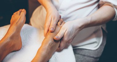 Bir kadına yapılan masaj salonundaki ayak masajının üst görüntüsü.