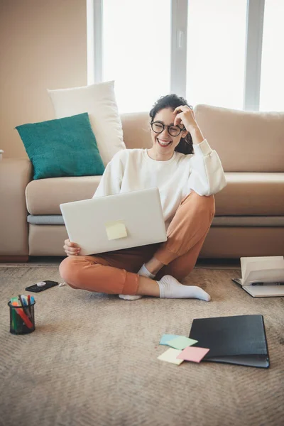 Gülümseyen beyaz kadın, oturma odasında dizüstü bilgisayarla online dersler alıyor. — Stok fotoğraf