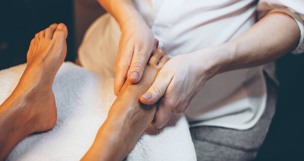 фотография массажа ступней в спа-салоне, сделанная женщине