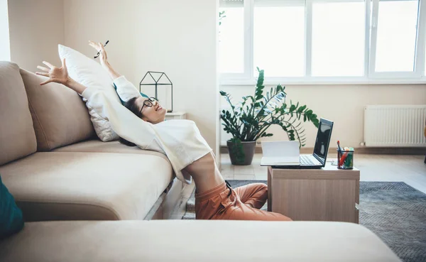 Mujer caucásica feliz estiramiento después de terminar las lecciones en línea en el hogar en el suelo — Foto de Stock