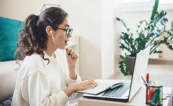 Beyaz kadın ödevlerini yaparken laptopta bir şey görünce şaşırdı. — Stok fotoğraf