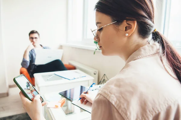 Back view photo of a young businesswoman chatting on phone while working at the desk with her man — Stock Photo, Image