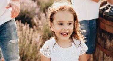 Beyaz elbiseli, beyaz elbiseli, beyaz elbiseli, anne babasının yanında poz veren beyaz bir kız.