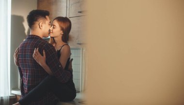 Kafkasyalı bir kadının arka plan fotoğrafı. Çilli bir kadın, aşığına sarılıyor. İki bacağı mutfakta öpüşüyor.