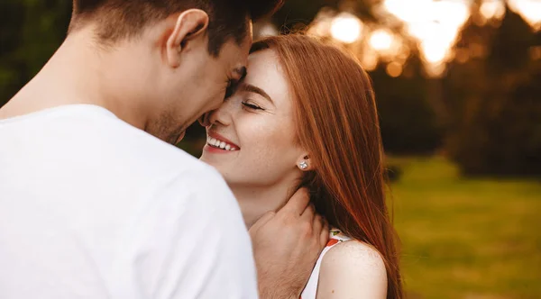 Voltar ver foto de uma senhora caucasiana com sardas e cabelos vermelhos e seu marido beijando e abraçando o parque — Fotografia de Stock