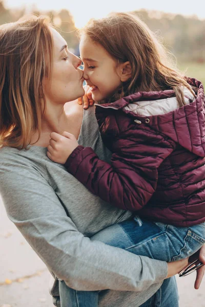 気をつけてお母さんキス彼女の娘と保持彼女の外で晴れた日に — ストック写真