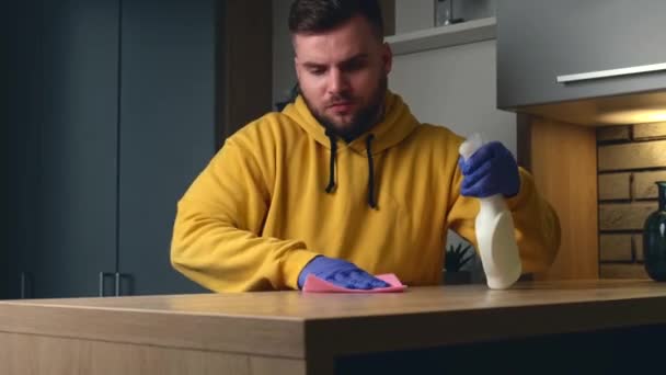 Blanke man met baard desinfecteert de tafel met alcoholische spray en handschoenen — Stockvideo