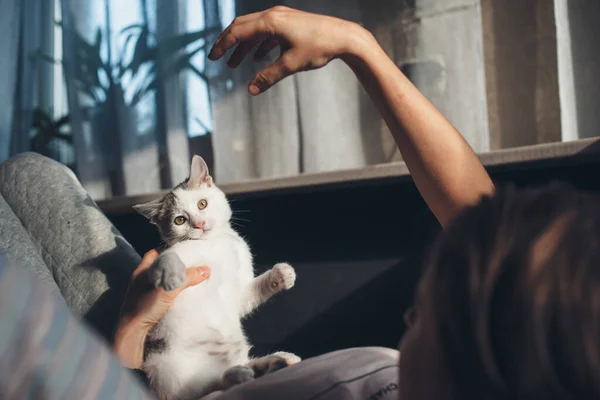 Kaukasische Brünette sitzt gemütlich im Bett und spielt mit ihrer Katze — Stockfoto