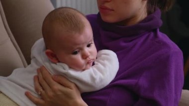 Beyaz tenli genç bir anne ve yeni doğmuş bebeği yatağında yatıyor.